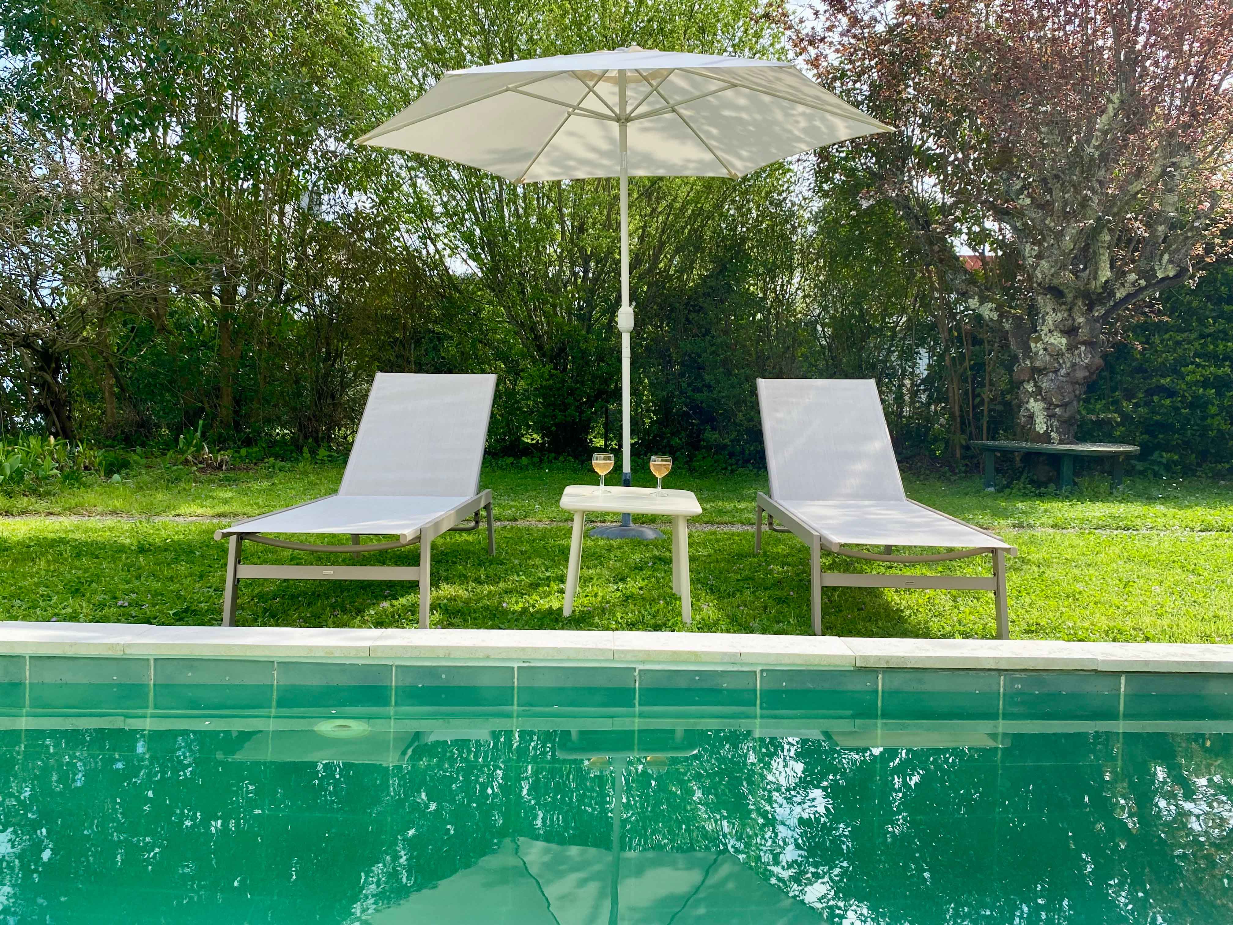Transats et parasol au bord de la piscine