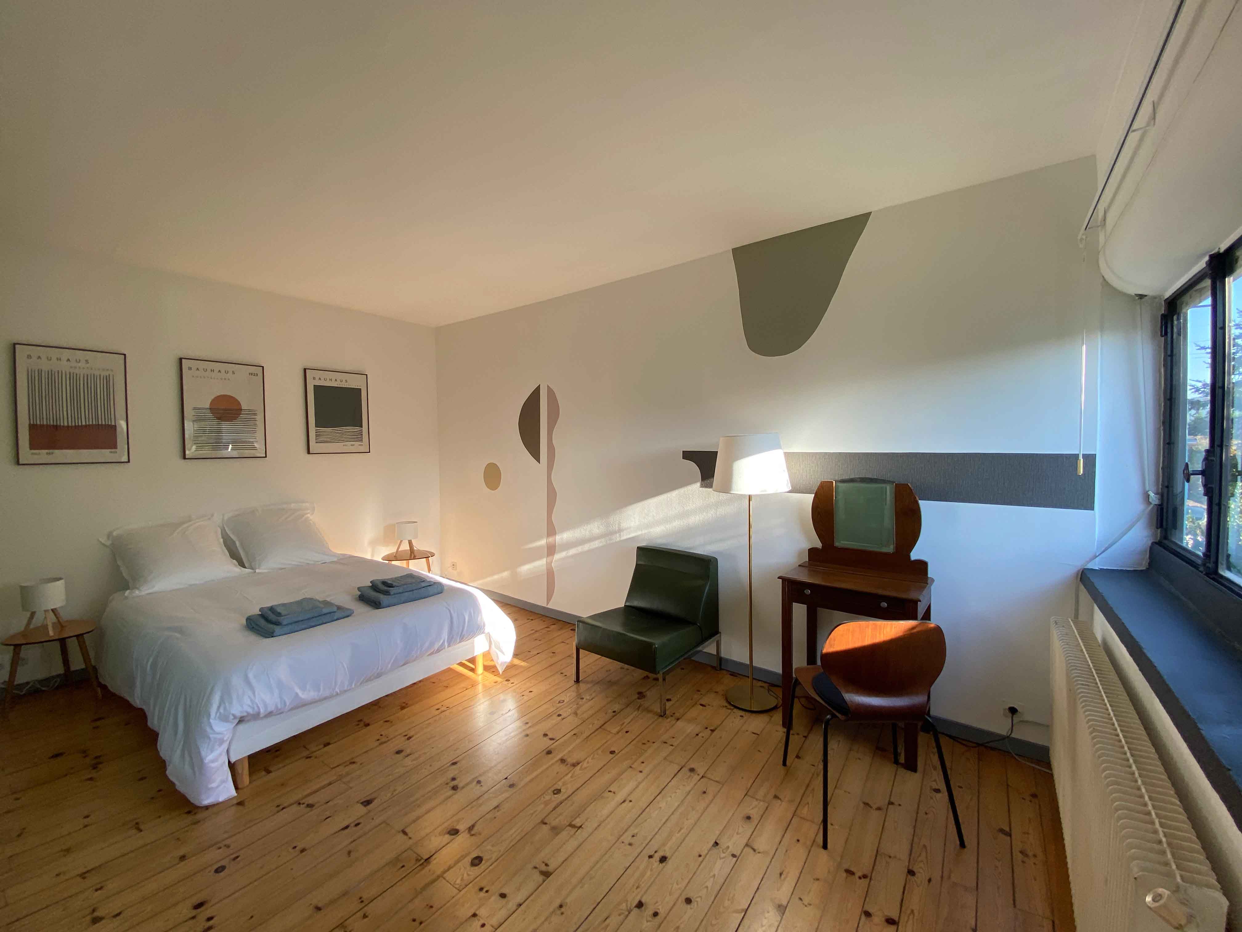 Chambre avec lit double et fresque murale