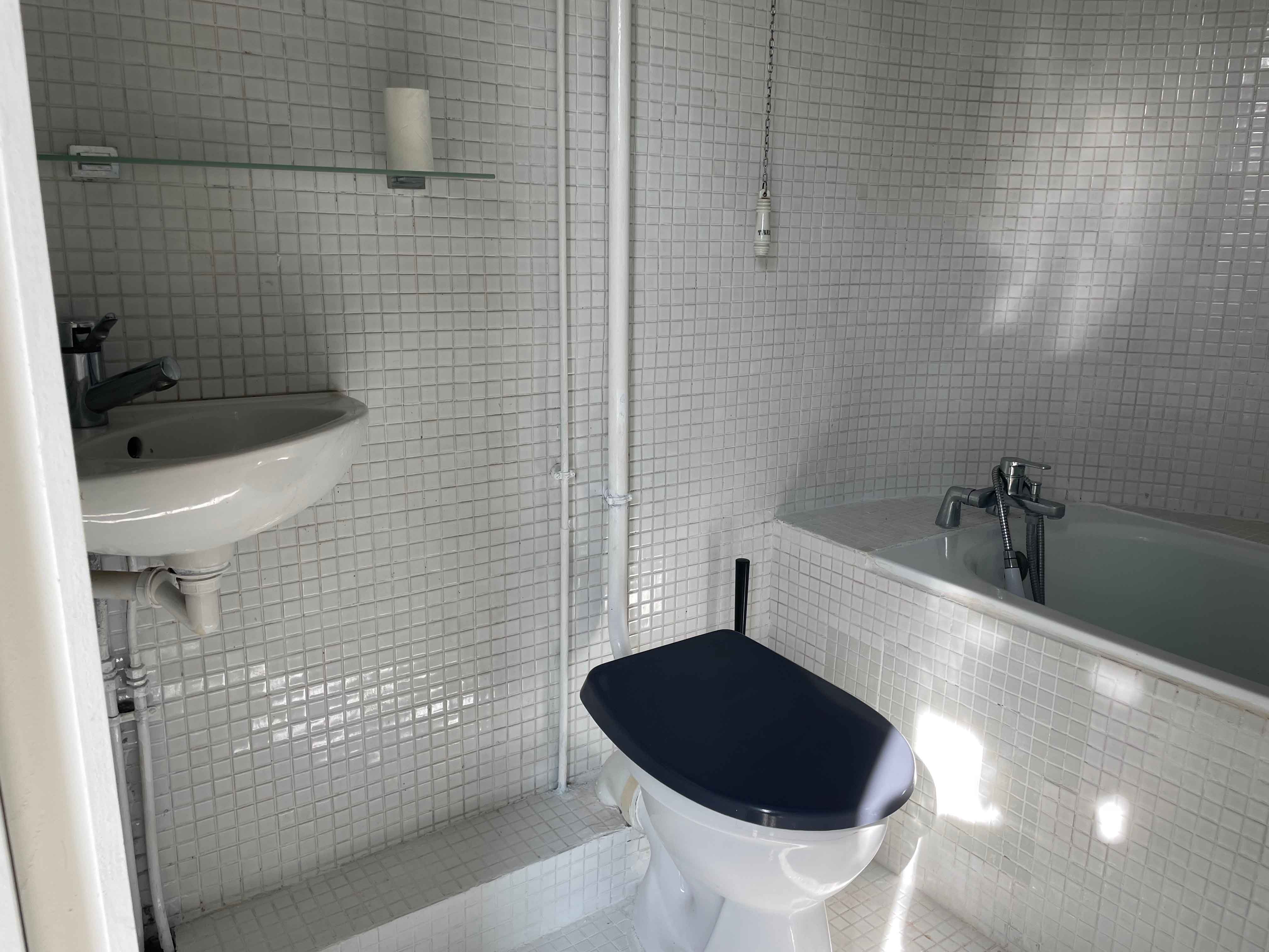 Salle de bain avec baignoire et mosaïque blanche