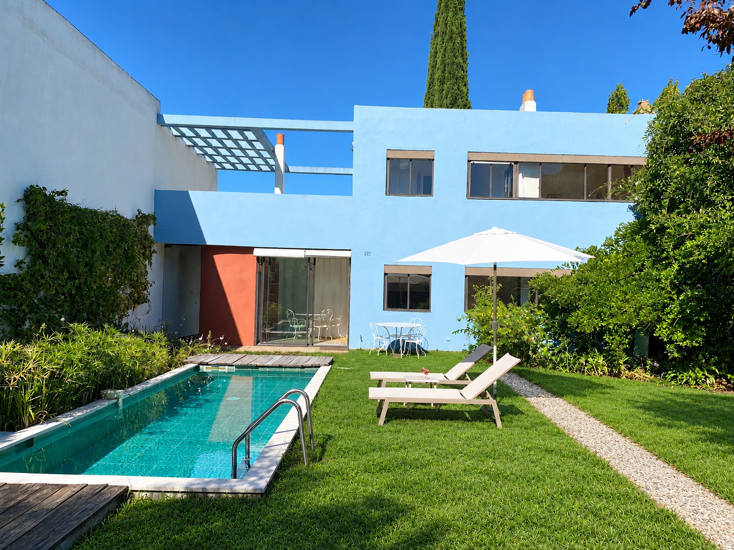 Jardin, piscine et façade bleue de la Villa ZigZag